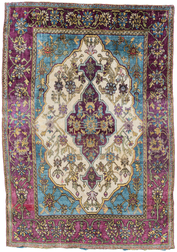 silk motashem kashan well balanced and energetic piece features a purple central medallion on a bright white ground surrounded by icy blue cornices and framed by a purple ground border. The blues and purples dyes are hallmarks of the famous atelier of Motashem as are the purple selvedges.The silk pile magnifies the top tier tones and contrast of this finely woven rug.The very precise and dense weave makes this rug exceptionally fine. Highly collectible and a delectable feast for both sight and touch