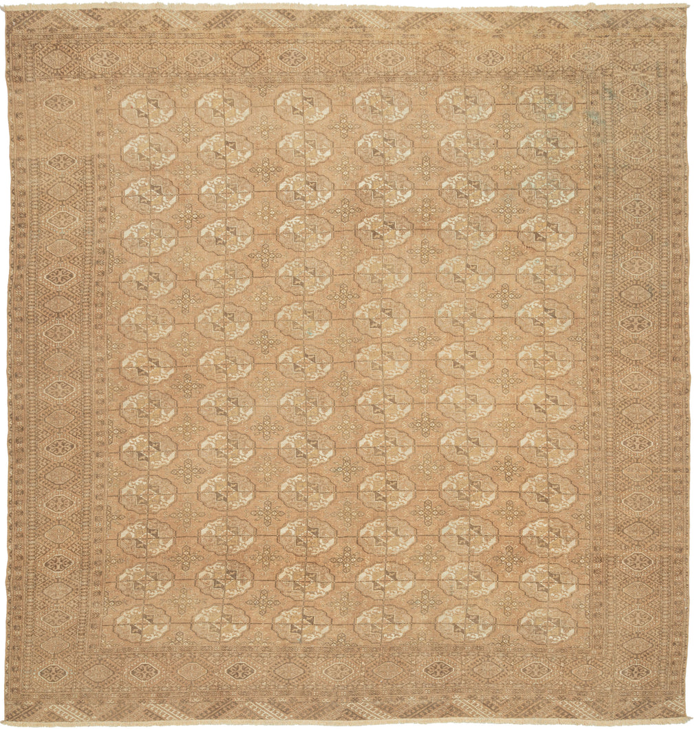 This Tekke Turkmen rug was handwoven during the second quarter of the 20th century in Turkmenistan.

The field features a grid of rounded main guls in various shades of brown, tan, bone and wheat on faded copper tone ground. The space between the grid is filled with rows of cruciform shaped secondary guls. It is encapsulated by a border of rams head filled octagons and finished with skirts of latch-hooked zigzags.