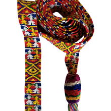 A vibrant woven cinta from Zunil, Quetzaltenango, Guatemala. This long headdress band is brocaded with repeating multicolored motifs, including geometric diamonds and stylized human figures in bright yellow, green, red, and white against a richly patterned ground. The ends finish in twisted multicolored tassels, typical of Zunil weaving.

Cintas are among the most distinctive elements of Maya women’s attire. They are wrapped elaborately around the head, creating a striking crown-like headdress, as seen in t