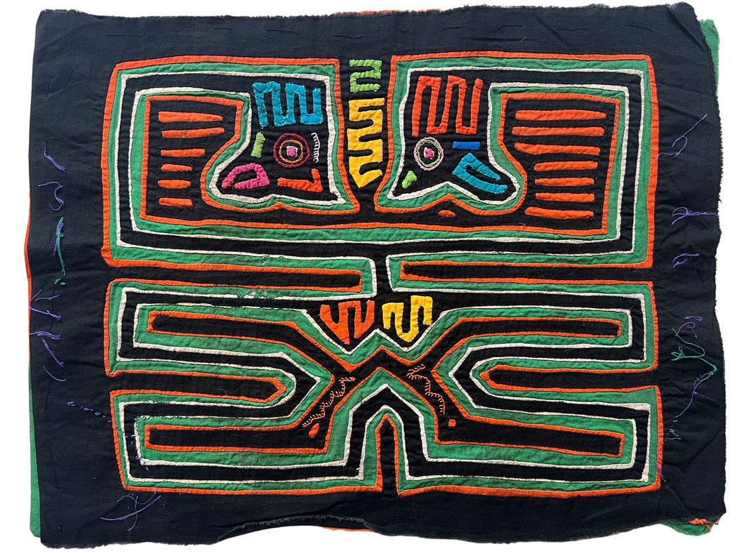 Vintage Mola cloth handmade by the Guna (previously spelled Kuna) people of the San Blas Islands.  Mola is a reverse appliqué technique, similar to the technique used in quilting but using multiple layers of different-colored cloth that are first sewn together before a design is created by cutting away different layers. These cloths are traditionally made in pairs to be worn on the front and back of women's blouses.  This Mola features colorful abstracted bird head forms.