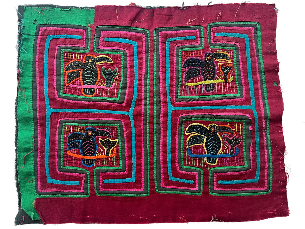 Vintage Mola cloth handmade by the Guna (previously spelled Kuna) people of the San Blas Islands.  Mola is a reverse appliqué technique, similar to the technique used in quilting but using multiple layers of different-colored cloth that are first sewn together before a design is created by cutting away different layers. These cloths are traditionally made in pairs to be worn on the front and back of women's blouses.  This Mola features four panels each featuring a hummingbird drinking nectar from a flower.