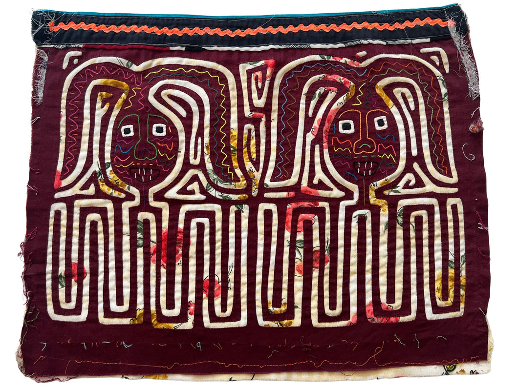 Vintage Mola cloth handmade by the Guna (previously spelled Kuna) people of the San Blas Islands.  Mola is a reverse appliqué technique, similar to the technique used in quilting but using multiple layers of different-colored cloth that are first sewn together before a design is created by cutting away different layers. These cloths are traditionally made in pairs to be worn on the front and back of women's blouses.  This Mola features what appear to be two bunnies. 