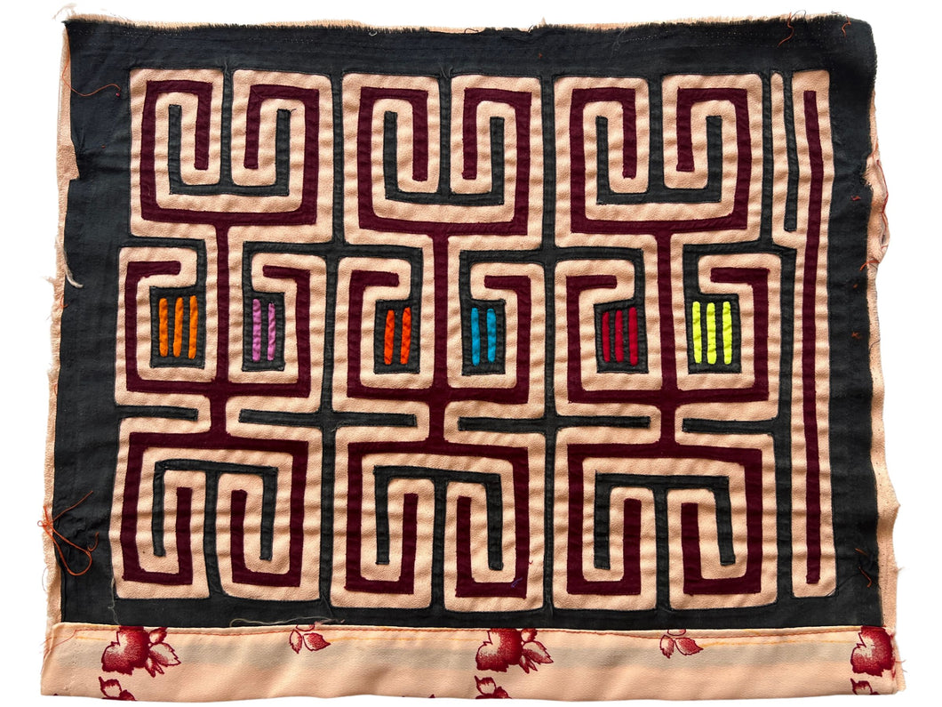 Vintage Mola cloth handmade by the Guna (previously spelled Kuna) people of the San Blas Islands.  Mola is a reverse appliqué technique, similar to the technique used in quilting but using multiple layers of different-colored cloth that are first sewn together before a design is created by cutting away different layers. These cloths are traditionally made in pairs to be worn on the front and back of women's blouses.  This Mola features a graphic geometric pattern on a black ground. 