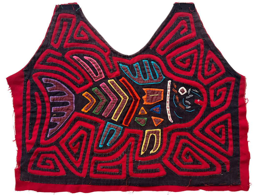 Vintage Mola cloth handmade by the Guna (previously spelled Kuna) people of the San Blas Islands.  Mola is a reverse appliqué technique, similar to the technique used in quilting but using multiple layers of different-colored cloth that are first sewn together before a design is created by cutting away different layers. These cloths are traditionally made in pairs to be worn on the front and back of women's blouses.  This Mola features a central fish and has cut into a blouse shape.  