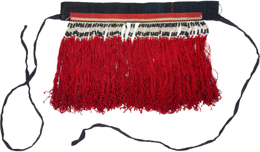 A rare traditional Dao Hồng Tụ back collar from Yên Bái Province, in the mountainous north of Vietnam. Created as a detachable panel worn over the back of a tunic, this piece represents a distinctive and highly expressive form of Dao women’s dress.

The upper band is composed of black cotton with a vivid red appliquéd strip, bordered by rows of white and dark antique glass beads. The beadwork forms a strong horizontal pattern, punctuated by small colored accents and geometric divisions. From this decorated 
