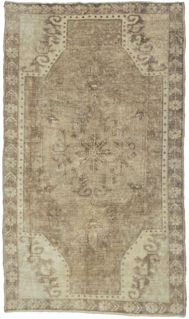 This Vintage Anatolian Rug features a central medallion on an open field with four cornices. The ornate patterning is softened by the limited palette of beiges and browns. Soft tones and limited contrast make this a very easy rug to decorate around.