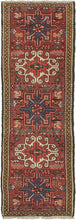 Vintage small Karaja runner featuring a pattern of alternating geometric shapes and hooked lozenges on a brownish-red ground. The ivory-hooked lozenges have a little more of an extra curl here giving it some distinct personality. Blues, purple, charcoal, gold, pink, and ivory complete the palette. In a rare narrow and short runner format.