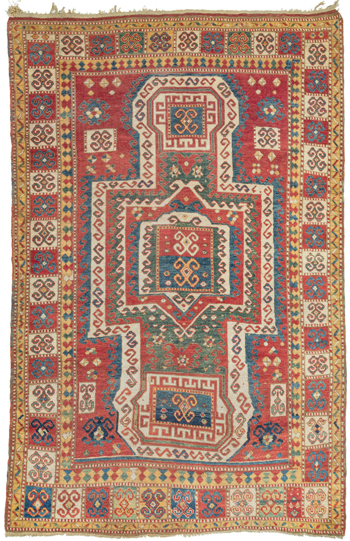 This Sewan Kazak was woven in the Caucasus during the 19th century. 

It features a variation of the classic rendition of the sewan design found in the Caucasus. The strong shield-like medallion is rendered here with a more boxier variation in a rich red, jade, indigo and an cheerful yellow. It is framed by latchooked filled sqaures that coordinate perfectly with the squarish medallion