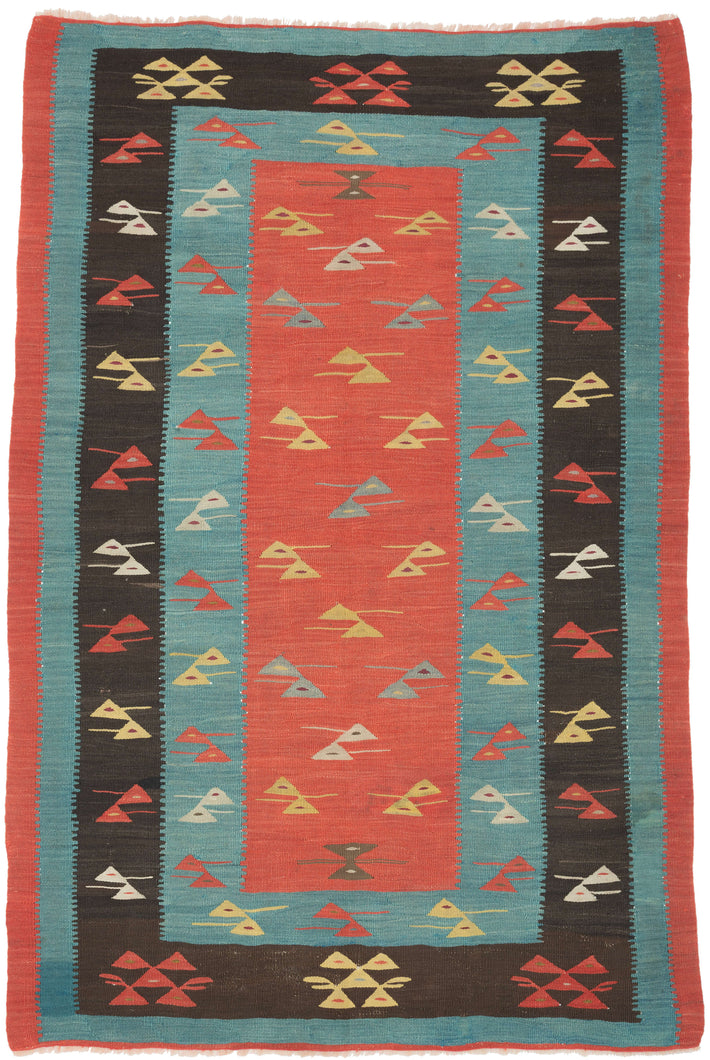 A beautifully balanced flatweave from the Balkan weaving tradition, this Sarkoy kilim features a striking interplay of color and form. The composition centers on a coral-red field framed by alternating turquoise and charcoal borders, each filled with stylized, abstracted bird motifs rendered in yellow, ivory, and crimson. The rhythmic repetition and crisp geometry lend the piece a distinctly modern sensibility while remaining rooted in folk symbolism and regional craftsmanship.

