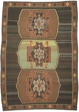 Vintage Kars kilim from eastern Turkey with three geometric medallions in brown and green tones, arranged within an open field with horizontal banding and framed by a border of small repeating diamond motifs.
