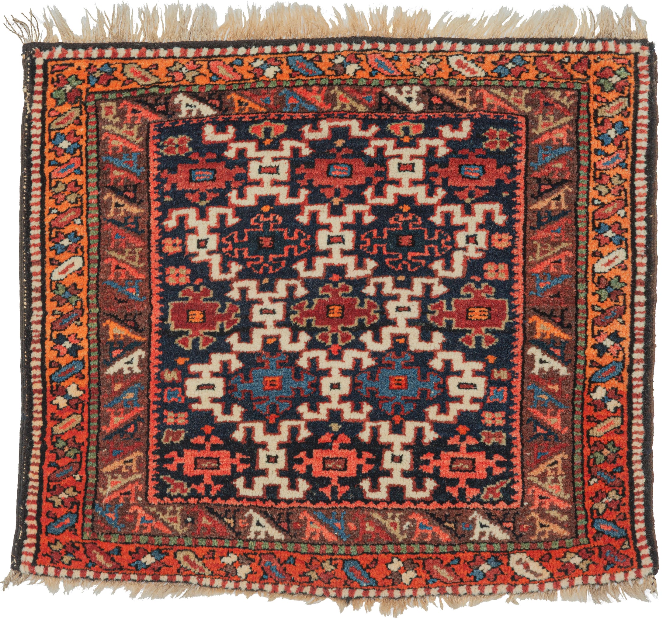 A lively Kurdish village rug handwoven during the second quarter of the 20th Century. It features a bold lattice field of hooked geometric motifs set against a deep indigo ground. The drawing is confident yet playful, typical of small tribal weavings from the Kurdish regions.

The borders animate the composition with stylized birds marching around the field. Along the outer border, beautiful abrash shifts from red to glowing orange, creating a soft tonal transition that evokes the warmth of a sunset.

