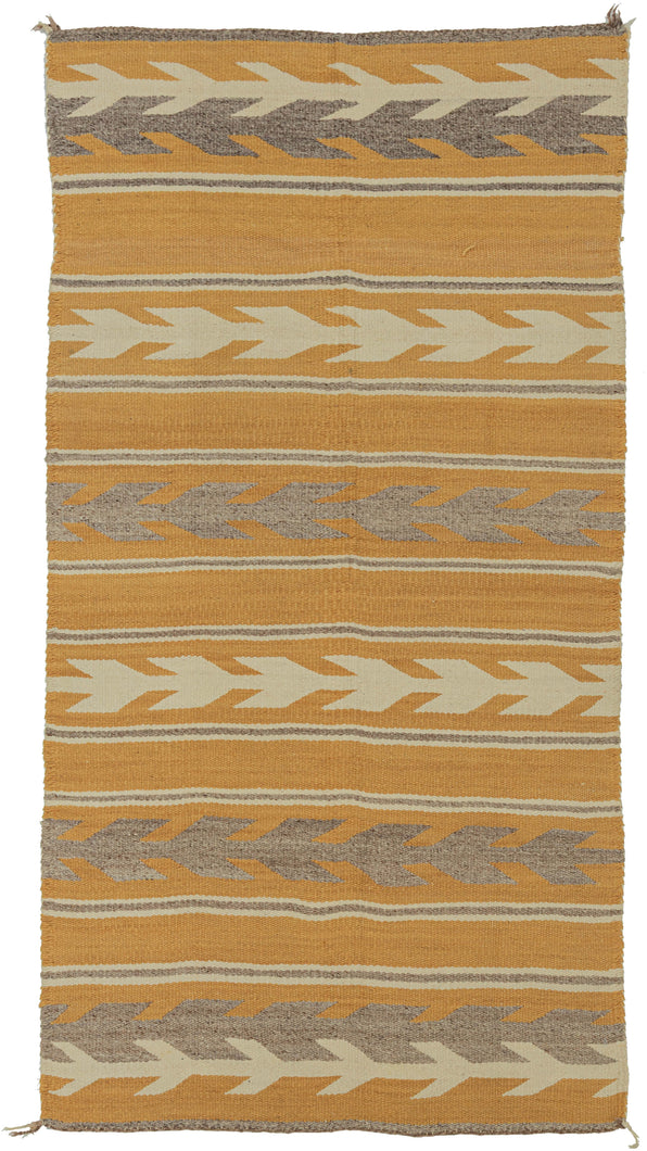 This Navajo rug was handwoven during the second quarter of the 20th century.

This Navajo rug features a warm golden fields framed by crisp stepped “arrow” or chevron bands in cream and a soft, muted purple. The alternating bands create a gentle, rhythmic movement across the textile. The palette is uncommon yet harmonious showcasing the beauty of handspun wool and classic Navajo design logic.