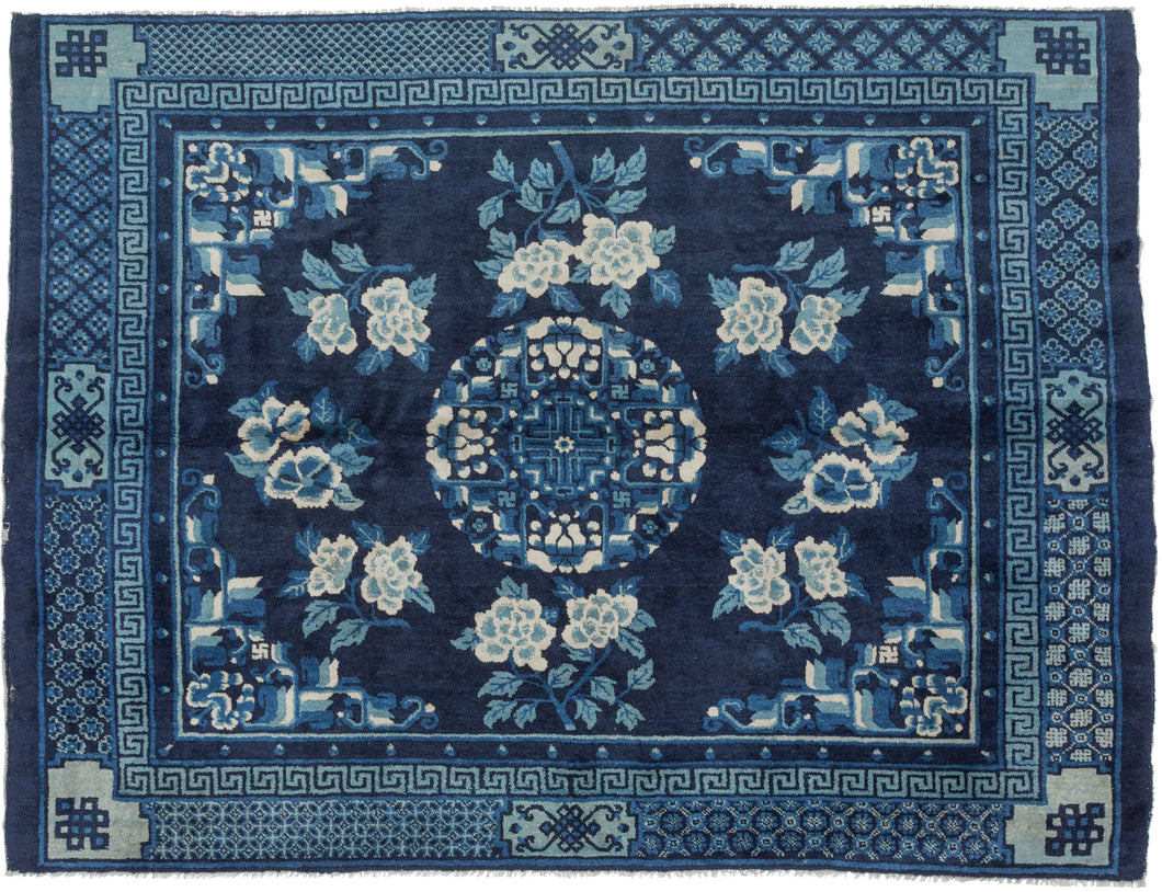 A luminous Ningxia rug woven in a sophisticated monochrome palette of deep indigo, sky blue, and soft ivory. At the center, a roundel of interlocking fretwork and stylized lotus motifs anchors the composition, surrounded by a generous spray of peonies that bloom across the field in balanced symmetry. The drawing is crisp yet fluid, displaying the gentle curvature and painterly shading characteristic of Ningxia weaving.

The border system is exceptionally rich with meandering key-fret bands, lattice grounds,
