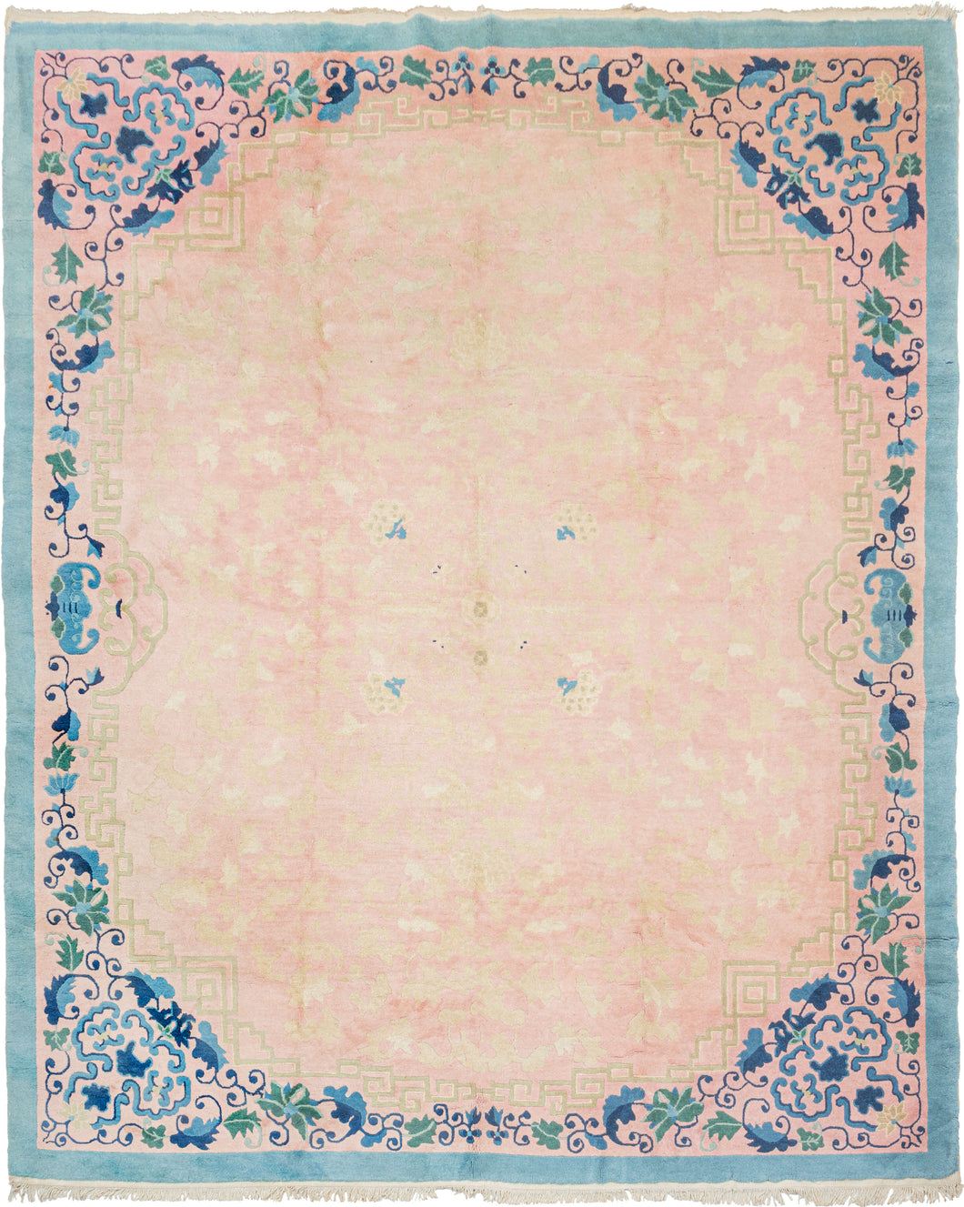A soft and atmospheric mid-century Chinese &nbsp;rug, distinguished by its pale pink field and beautifully balanced border of celadon and layered blues. The open interior shows a subtle shadow-pattern of scrolling vines, giving the rug quiet depth and movement. Stylized blossoms and stepped fretwork corners frame the composition with a refined, modern clarity.

Rooted in traditional Peking design yet updated for mid-century tastes, this piece offers a serene, versatile palette ideal for contemporary interio