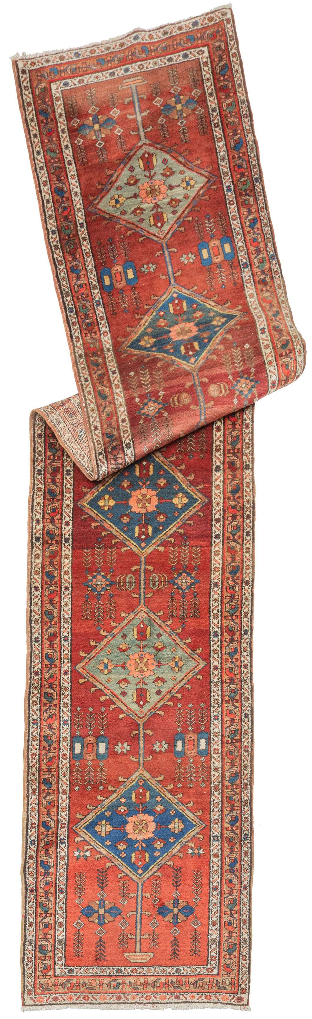 A lively Heriz runner with a warm rust-red field anchored by a vertical chain of diamond medallions in soft blue and pale green. Each medallion encloses stylized floral rosettes, while small geometric motifs and delicate plant forms fill the surrounding space with rhythmic detail.