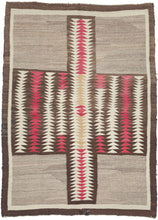 This exceptional vintage Navajo weaving is distinguished by its remarkably bold and unconventional composition. A dramatic abstracted butterfly or cruciform motif anchors the design, its rhythmic serrated forms creating a striking sense of movement while broad expanses of natural gray wool provide a calm, spacious counterpoint. The result is a textile that feels both deeply rooted in tradition and distinctly modern.