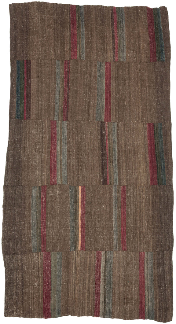 An early 20th century Dolpo blanket woven from handspun wool in the high Himalayan region of northwestern Nepal. Constructed from joined panels, the surface carries a quiet patchwork rhythm created by subtle shifts in tone and the intentional rotation of narrow striped bands.