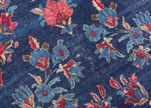 An elegant vintage Tabriz carpet distinguished by its unusually deep indigo-blue field and spacious floral drawing. A softly articulated central medallion anchors the composition, surrounded by scrolling vines, palmettes, blossoms and delicate boteh rendered in saturated shades of cornflower and sky blue, rose, coral, red, celadon, camel and ivory.