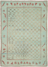A wonderfully unusual handwoven rug with a soft aqua ground and an intricate allover network of small geometric forms in taupe, gray, and faded blue. The dense central field is surrounded by a much more open border populated with quirky, almost pictographic motifs in brick red and charcoal. 