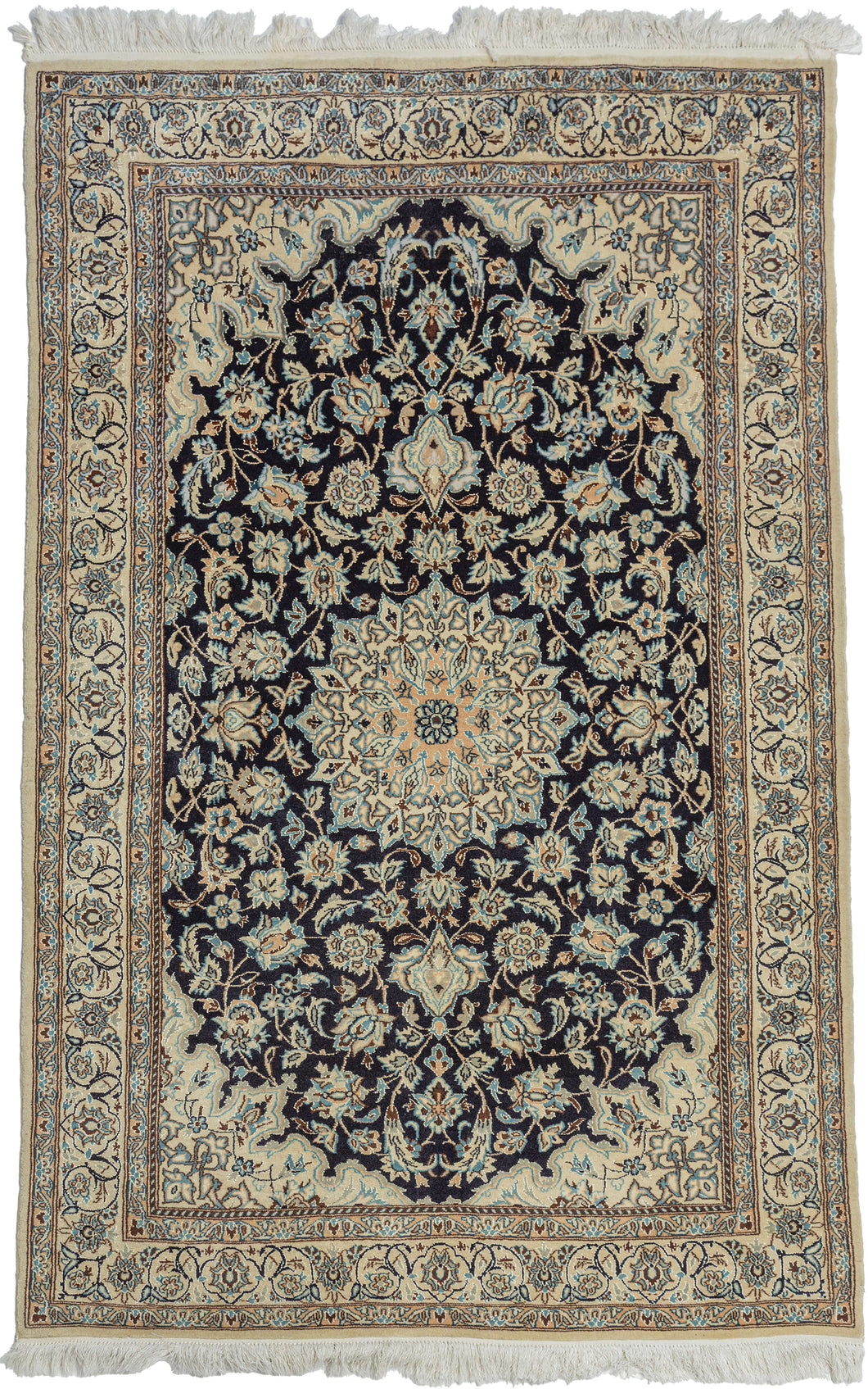 This elegant vintage Nain rug reflects the refined craftsmanship and timeless floral aesthetic for which these weavings are celebrated. A deep midnight navy field is anchored by an intricate ivory and camel medallion, surrounded by gracefully scrolling arabesques, palmettes, and delicate flowering vines. The luminous ivory spandrels and finely detailed floral borders create a striking contrast, giving the composition exceptional clarity and balance.