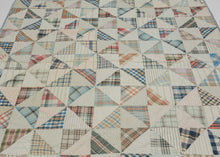 This vintage patchwork quilt was crafted in North America during the middle of the 20th century.


It features patch-worked grid composed of squares. Each square is formed of well balanced triangles of either colorful flannel patterns or more open dotted and striped cream ground patterning. The squares have been pieced together wondefully and the composition can be read many different ways that is accentuated by its perfectly square dimensions.