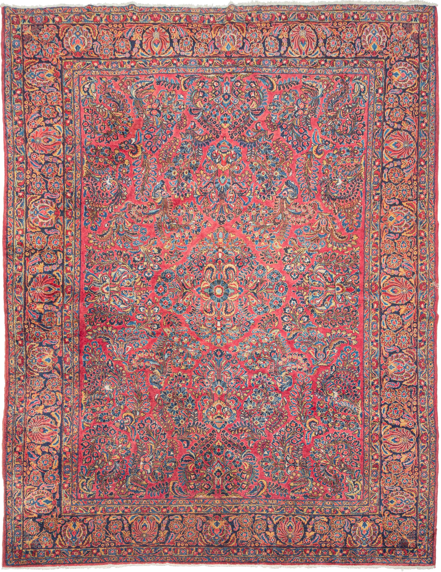 A refined and authoritative example of 1920s Sarouk weaving, well suited to anchoring a room with both elegance and visual richness. It features a dense, symmetrical arrangement of scrolling vines, palmettes, and floral sprays organized around a clearly articulated yet well-blended central medallion. The composition is balanced and expansive, with a sense of movement that carries easily across the larger scale without becoming heavy or overcrowded.