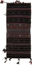 A richly textured saddle bag from Afghanistan with silky wool, woven in a dark, atmospheric palette of deep brown, black, aubergine, red, and indigo tones. The design is arranged in vertical bands with small geometric motifs, zigzag borders, diamond forms, and subtle embroidered details.