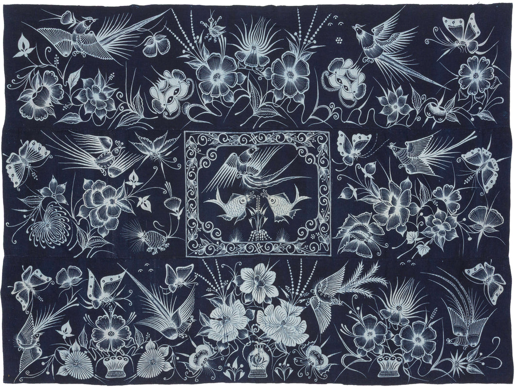 A striking Miao batik wall hanging or coverlet on a deep indigo ground, densely animated with birds, butterflies, fish, flowers, and curling vines in white wax resist. The imagery draws on a rich symbolic vocabulary associated with the natural world, fertility, abundance, renewal, and continuity.