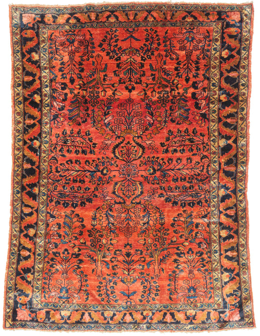 This finely woven Lilihan features a rich coral-red field animated by a balanced arrangement of flowering vines and stylized botanical motifs. The composition is formal yet lively, with mirrored elements that give the rug structure while allowing the drawing to remain fluid and expressive.