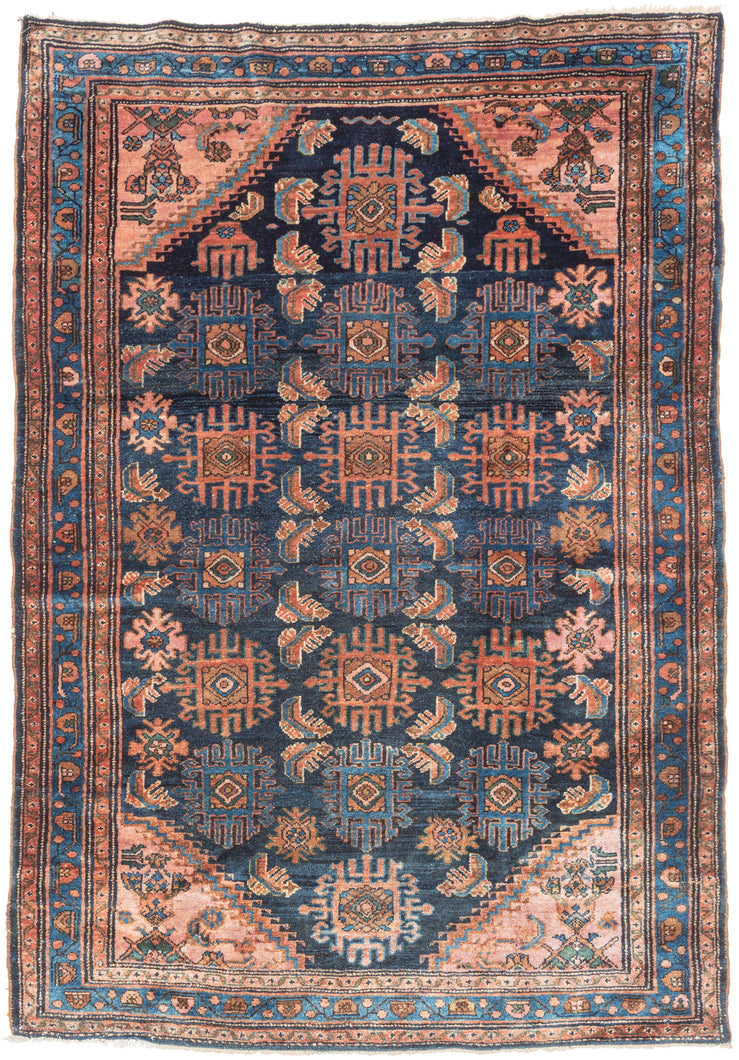 This Hamadan rug presents a classic village composition with a direct, confident hand. An allover design unfolds across a navy ground, featuring a fresh palette of earthy reds and rust tones balanced by indigo, soft ivory, and subtle accents of blue and green. Coral cornices brighten the field, while a fluid blue border frames the composition, flowing around the perimeter like a pool of water.