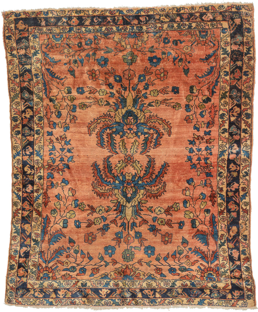 This cheerful Lilihan is distinguished by an especially striking mirrored bouquet motif, in which scrolling vines grow from two central bouquets, each adorned with large, hanging serrated leaves. Set against a warm coral field, the design feels both formal and expressive, with the unusual mirrored botanical elements radiating outward in a balanced, confident arrangement.