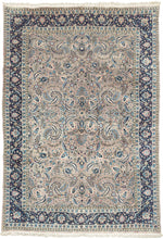 This Mashad rug was handwoven during the middle of the 20th century.

It features an allover design that radiates from a central axis with mirrored sprays of stylized palmettes, saz leaves and rosettes in shades of icy blue, indigo, shell pink and ivory on a silver ground. Nicely framed by a perfectly reconciled main border of palmettes on a midnight blue ground. The original ground color was a purple tone that was not color fast and has perfectly faded into a cool silver tone which is very uncommon in vint