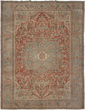 A commanding Heriz rug distinguished by a more ornate, curvilinear drawing than the classic, highly angular Heriz style. The richly saturated red field is centered by a large, radiating medallion with scrolling floral forms that lend fluidity and movement to the composition.