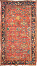 It features a dense and rhythmic allover pattern of palmettes, rosettes, and roving vinery set against a richly saturated madder red field.&nbsp;Lush floral clusters and shield-like medallions in blues, golds, ivory, and greens are symmetrically arrayed across the surface, producing a mesmerizing, layered composition.&nbsp;The deep indigo border is animated with bold palmettes and angular vine scrolls, grounding the exuberant interior with contrast and balance. This carpet’s large format and harmonious pale
