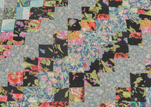 This vintage patchwork quilt was crafted in North America during the middle of the 20th century.


It features patch-worked squares of various fabric in rows of serrated stripes organized on the diagonal. Many of the squares feature there own detailed patterning which adds interest and touch of fun! Much of the stitching has been completed by hand included large visible running stitches in black giving the piece a kantha-like feel.