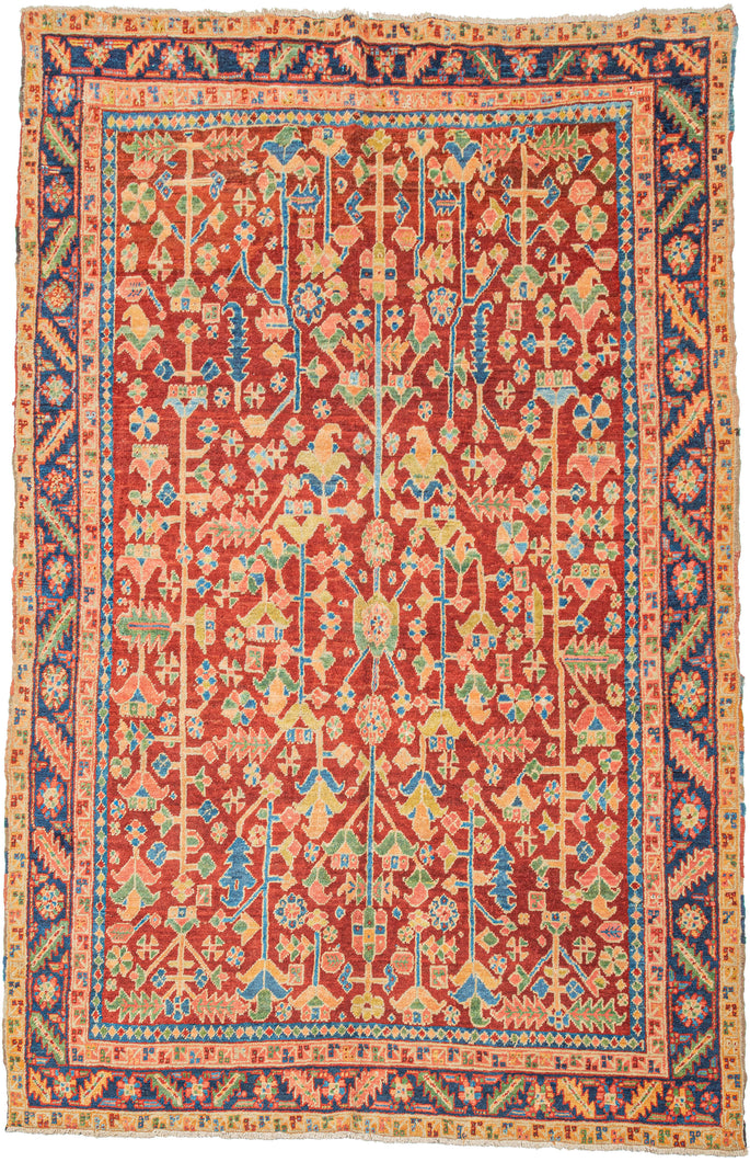 A joyful and highly decorative Heriz from the second quarter of the 20th century.

This piece is distinguished by its less common allover shrub and blossom field in lieu of the familiar central medallion. The shifting botanical forms, serrated leaves, and angular palmettes are rendered in a vivid yet harmonious palette with a brick red ground and accents of sky blue, soft yellow, celadon, apricot, and deep indigo accents. 