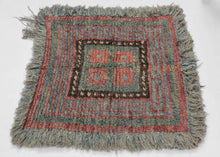 A compact Tibetan Wangden woven in the Wangden Valley of eastern Tibet, organized around a bold nested square composition. Stepped meanders radiate outward from a central panel, creating a rhythmic, architectural framework that balances symmetry with subtle irregularity. The palette of muted coral, slate blue, and mineral green is anchored by a dark brown inner border punctuated with small ivory accents.

Woven in hand-spun wool with a dense, springy pile, the piece retains its original long fringe and disp