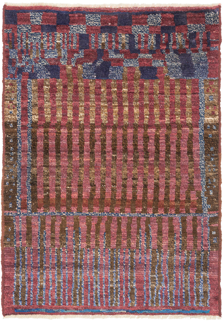 This striking composition exemplifies the bold modernism that can found in Morocco’s weaving tradition. Geometric and architectural in sensibility, the design features a structured grid of vertical and horizontal bands in shades of rose, olive, and indigo creating a rhythmic, almost musical interplay of line and color. The subtle irregularities of handwoven technique lend the piece warmth and movement, softening its graphic precision.