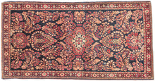 This finely woven Sarouk exemplifies the lush floral language that made the region’s carpets among the most sought-after of 1920s. Set against a deep midnight-blue ground, an intricate lattice of scrolling vines, palmettes, and rosettes unfolds with remarkable density and clarity, anchored by a subtle central medallion that gives structure to the otherwise allover composition.