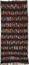 This Karabaugh kilim features horizontal row of stars or abstracted flowers in light and dark brown, soft greens, slate and vibrant red and orange on a black ground. The pattern is simple but interesting and can be read multiple depending on what the viewer focuses on. Woven of hearty handspun with the undyed brown warps adding an additional aesthetic dimension.