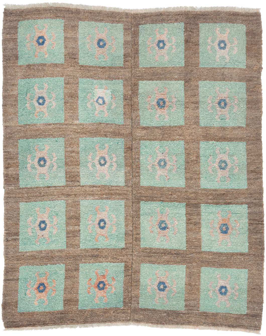 A wonderfully graphic vintage latch-hook rug with a repeating grid of aqua panels, each centered by a playful abstract motif in soft blush, salmon, and deep blue. The warm brown ground gives the composition structure while allowing the almost cellular, biomorphic forms to float across the surface.