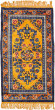 This silk rug was handwoven during the 3rd quarter of the 20th century in Tianjin, China.It features a central medallion of delicate ivory flowers surrounded by a floral and serrated leaf fretwork in mutilple blues, pinks, red and green on a yellow ground. The whole is framed by a border of blossoming vines on a copper ground. Nicely finished with golden fringes adding further distinction.