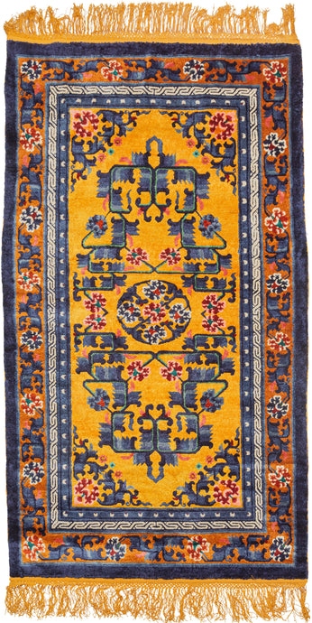 This silk rug was handwoven during the 3rd quarter of the 20th century in Tianjin, China.It features a central medallion of delicate ivory flowers surrounded by a floral and serrated leaf fretwork in mutilple blues, pinks, red and green on a yellow ground. The whole is framed by a border of blossoming vines on a copper ground. Nicely finished with golden fringes adding further distinction.