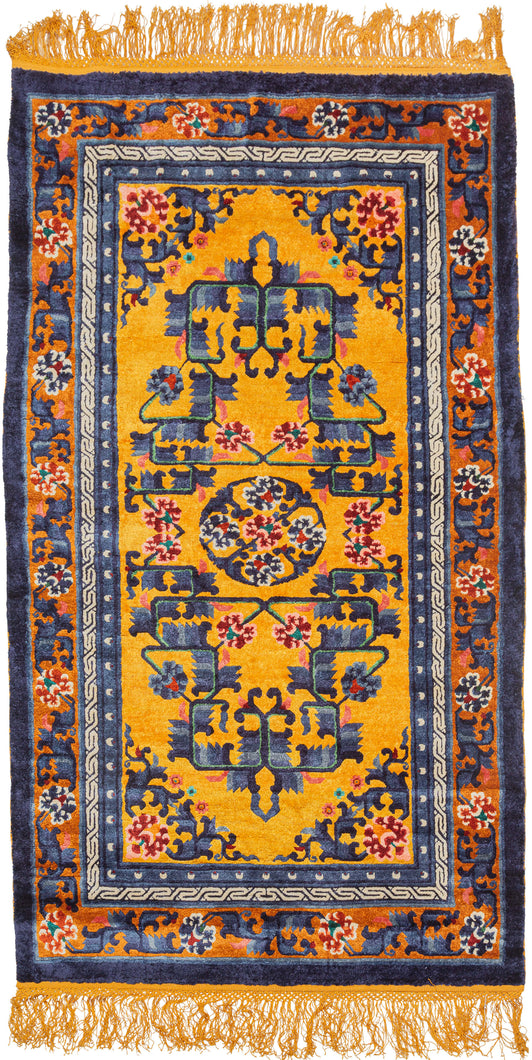 This silk rug was handwoven during the 3rd quarter of the 20th century in Tianjin, China.It features a central medallion of delicate ivory flowers surrounded by a floral and serrated leaf fretwork in mutilple blues, pinks, red and green on a yellow ground. The whole is framed by a border of blossoming vines on a copper ground. Nicely finished with golden fringes adding further distinction.
