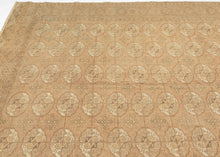 This Tekke Turkmen rug was handwoven during the second quarter of the 20th century in Turkmenistan.

The field features a grid of rounded main&nbsp;guls in various shades of brown, tan, bone and wheat on faded copper tone ground. The space between the grid is filled with rows of cruciform shaped secondary guls. It is encapsulated by a border of rams head filled octagons and finished with skirts of latch-hooked zigzags.