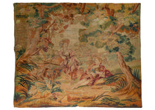 Antique French Aubusson tapestry featuring a scene of two women enjoying a lush outdoor landscape. Both are barefoot and wearing fine fabric clothing. One woman is standing while holding a picnic basket as the other is seated on the ground with a bagpipe. What appears to be a dog can be seen in the background between them.