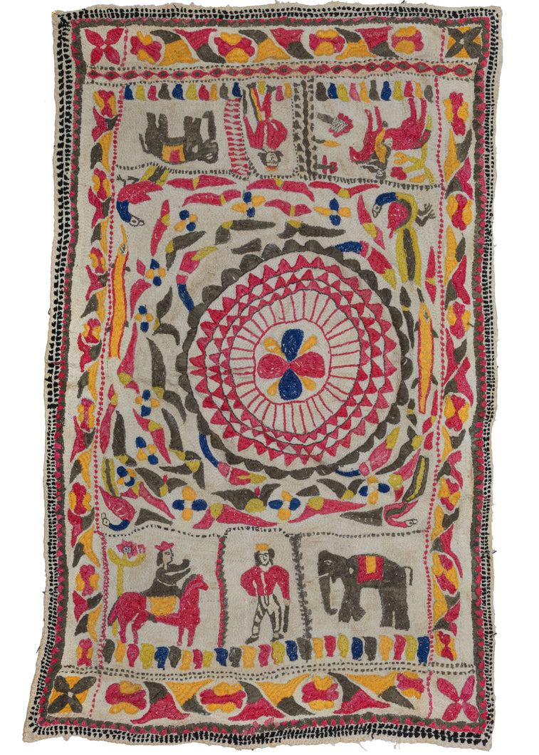 Antique Nakshi Kantha featuring an off-center mandala with three reciprocal panels on top and bottom. The panels feature an elephant, a person on horseback, and what appears to be a rendition of the British hunter motif. It is framed by an alternating rosette and leaf border reminiscent of the classical egg and dart style. At the four corners of the border is a single rosette.