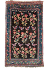 Antique Caucasian Armenian Karabagh area rug featuring a design of partridges and cabbage roses floating above a deep black field.  An inscription featuring a name and date in Armenian at the top:  "13 March 1932 Vardider Yerzinkyan"  In excellent condition with little to no signs of wear. Thick pile, woven in a full lustrous wool, with a soft handle. 
