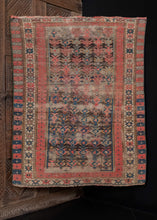 Antique Caucasian Kuba rug, handwoven during the first quarter of the 20th century. The rug is composed of a geometric design arranged diagonally, with alternating rosette and crab borders. The color palette includes bright red, deep blue, ivory, and brown, which has oxidized. In fair condition, with signs of wear throughout, 