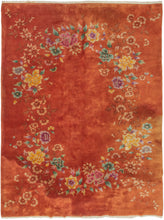 Chinese orange floral modern deco rug featuring various blossoming flowers arranged in an oval garland atop a sumptuous paprika ground. The eye-catching design features peonies, chrysanthemums, and fruit blossoms among flowers rendered in greens, yellows, pinks, and purples that really pop. 